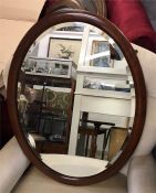An oval mahogany framed bevel edged mirror