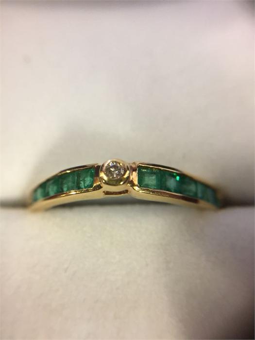 An 18ct Yellow Gold half eternity ring set with ten emeralds and a diamond