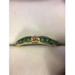 An 18ct Yellow Gold half eternity ring set with ten emeralds and a diamond