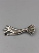 A silver and marcasite brooch in the shape of a hand.