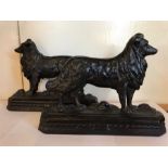 A pair of cast iron dog door stops