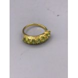 A 9ct gold ring set with a line of peridot