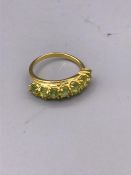 A 9ct gold ring set with a line of peridot