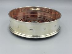 A silver, hallmarked wine bottle coaster, engraved.