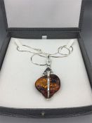 A silver and amber pendant