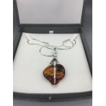 A silver and amber pendant