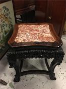 An Oriental marble topped table on claw and ball feet