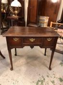 An small oak desk with three drawers and brass handles