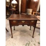 An small oak desk with three drawers and brass handles