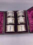 A boxed set of six silver napkin rings