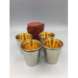 A set of four white metal stirrup cups with gilded insides in original hide case