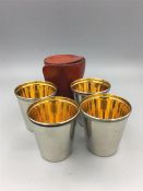 A set of four white metal stirrup cups with gilded insides in original hide case