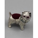 A silver dog pin cushion set with rubies and emerald collar