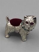 A silver dog pin cushion set with rubies and emerald collar