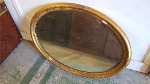 A gilt oval mirror