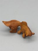 A wooden Japanese Netsuke in the form of a fish signed to the base