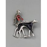 A silver brooch in the form of an Art Deco Lady walking her dog enamel set