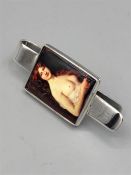 A silver money clip with nude enamel image