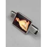 A silver money clip with nude enamel image