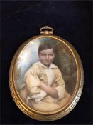 An Oval Miniature showing a Young Boy sitting with folded arms in front of a wooded background,