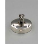 A silver pill box with bear to the lid