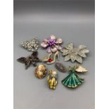 A selection of brooches to include a silver and garnet butterfly