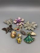 A selection of brooches to include a silver and garnet butterfly