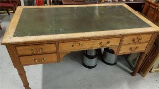 A leather topped desk over five drawers