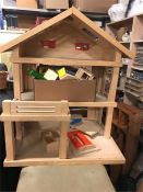 A Wooden Dolls House with wooden furniture