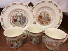 A selection of Bunnykins Christening Ware, three mugs and two plates.