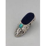 A substantial silver pin cushion in the form of a shoe inset with opal.