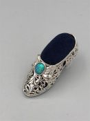 A substantial silver pin cushion in the form of a shoe inset with opal.