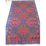 An Afgan hand-knotted herathi balouchi burgundy-ground wool rug with multicoloured isometric