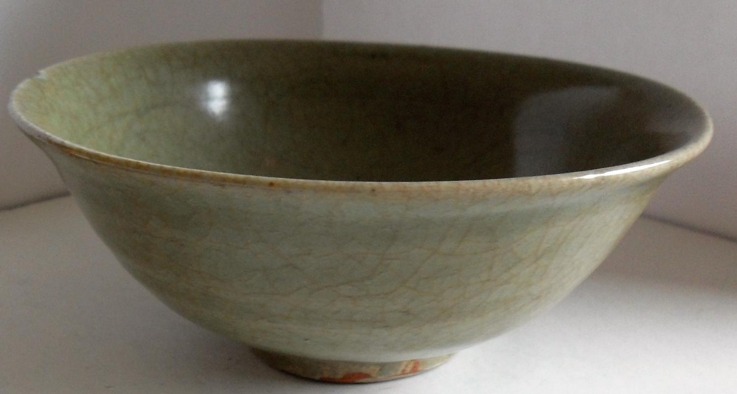 A Chinese Song Dynasty 960-1279AD celadon bowl on single foot with internal incised scrolling