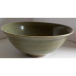 A Chinese Song Dynasty 960-1279AD celadon bowl on single foot with internal incised scrolling