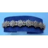 A gold and diamond bracelet comprising eighteen clusters of nineteen brilliant cut diamonds, (