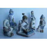 A Lladro seated figurine of a girl with kitten and weighing scales, a seated Eskimo child with