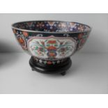 A Chinese famille noire polychrome circular bowl with chrysanthemum decoration on wooden stand 12