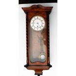 An early 20th century walnut-cased Vienna-style wall clock with moulded cornice and turned