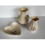 A Belleek vase with thistle decoration and a Donegal parian ware heart-shape dish and a vase (3) all