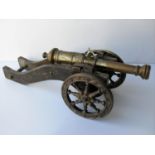 A miniature brass cannon mounted on a wooden frame dated MDLXX (1570), 31 cm wide