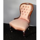 A Victorian mahogany-framed spoon back nursing chair with button-back fabric upholstery on turned