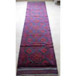 An Afghan hand-knotted Meshwani blue-ground wool runner with multi-coloured lozenge designs,