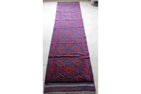 An Afghan hand-knotted Meshwani blue-ground wool runner with multi-coloured lozenge designs, - Image 1 of 2