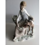 A Lladro figure of a seated young girl feeding a calf - repair to head and neck of calf
