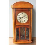 An early 20th century oak-cased wall clock with Arabic numerals, in working order