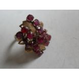 An 18k yellow gold dress ring with a wire cage cluster of garnets, size M, hallmarked, 5.2g