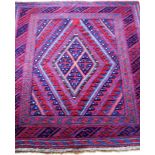 An Afghan hand-woven tribal Kazak blue-ground wool rug with multi-coloured lozenge decoration,
