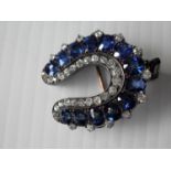 An Edwardian gold, silver, sapphire and diamond horseshoe brooch with thirteen cushion-shaped