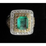 An emerald and diamond three-tier square cluster ring with diamond set shoulders. Emerald approx.